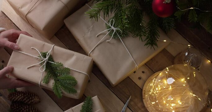 Christmas Presents Wrapped In Eco-friendly Craft Paper Decorated With Twines And Sprigs Of Festive Foliage. overhead