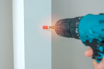 man using a cordless screwdriver assembling furniture at home, Carpenter working with electric screwdriver on the work