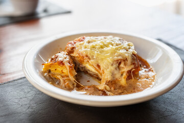 lasagna on white plate in restaurant