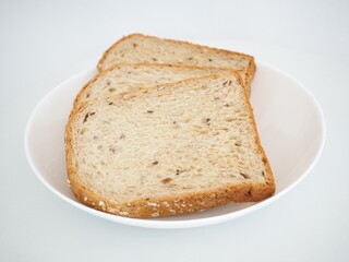 Whole grain bread on a white plate. Closeup photo, blurred.