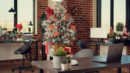 Business office decorated with christmas tree and lights to celebrate holiday festivity during winter season. Empty space filled with xmas decorations and ornaments, seasonal tradition.