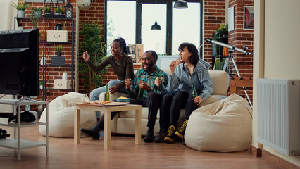 Excited people celebrating footbal team winning championship, feeling happy about goal score to win tournament. Happy soccer fans cheering and showing support on television channel.