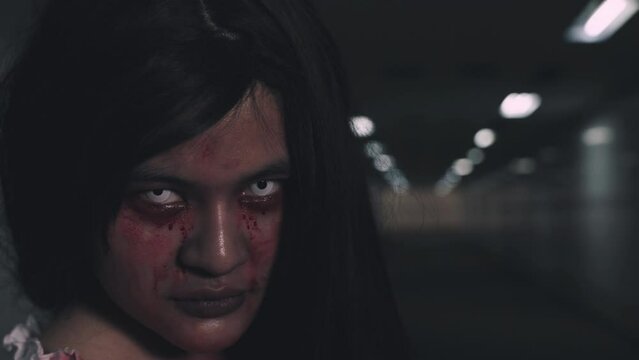 Bloody halloween makeup. horror bloodthirsty ghost female turn around with fade drop out from eyes, Asian woman with blood eye turn back and scary with blood tear on face, Happy halloween day concept