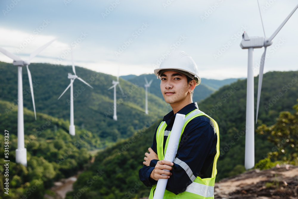 Wall mural young maintenance engineer man holdind blueprint on the mountain.