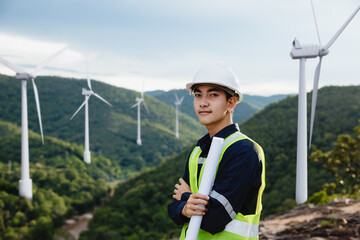 Young maintenance engineer man holdind blueprint on the mountain.