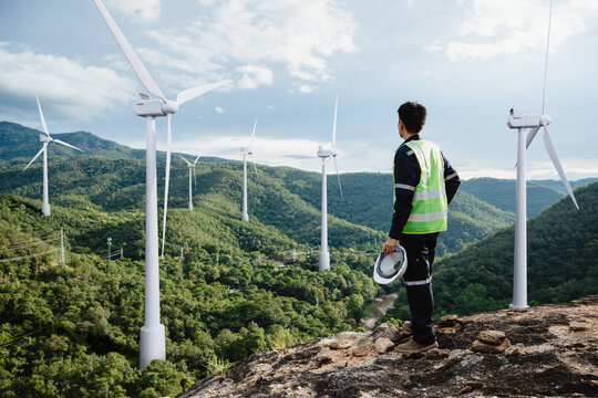 Young maintenance engineer man working in wind turbine on the mountain