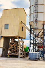 Concrete mixer truck in front of a concrete batching plant, cement factory. Loading concrete mixer...