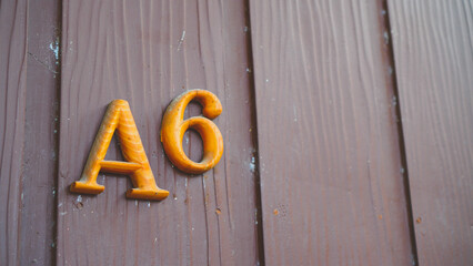 House Number A6 On An Brown Wooden Wall