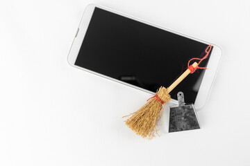スマートフォンと、玩具の掃除道具。スマートフォンのクリーンアップのイメージ