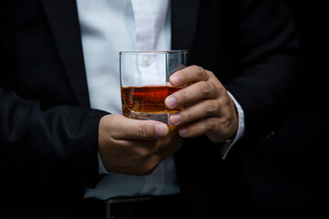 Closeup businessmen holding a glass of whiskey