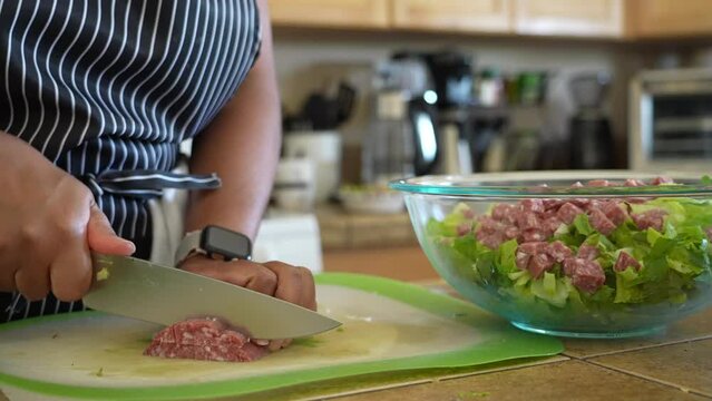 Cutting and slicing salami to serve over antipasto chopped salad - ANTIPASTO SALAD SERIES