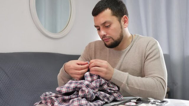 Young woman repairing clothes with a needle and thread