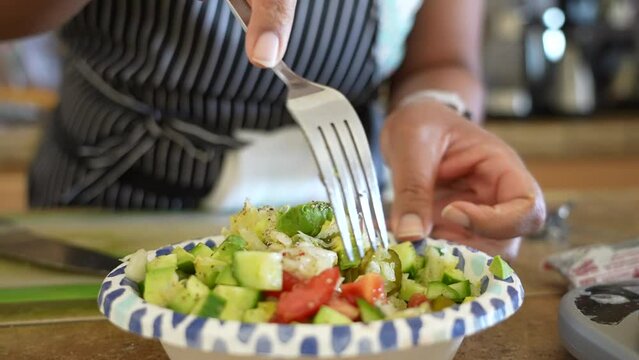 Mixing  sauerkraut tomato cucumber in a homemade snack