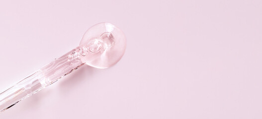 banner glass pipette serum closeup on a light pink background