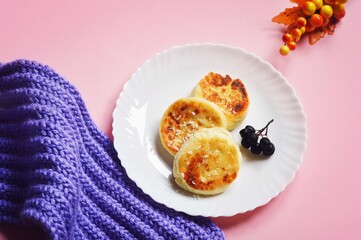 Delicious cottage cheese pancakes and coffee cup on a pink table. Winter breakfast still life food photography