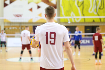 Fototapeta premium Volleyball player before service on the playing field. View from the back