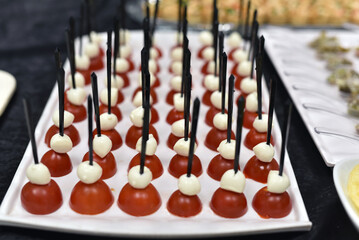 Snacks consisting of tomatoes and cream on them are served quickly on a tray