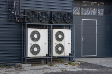Air conditioning chiller units mounted on a frame near a building wall