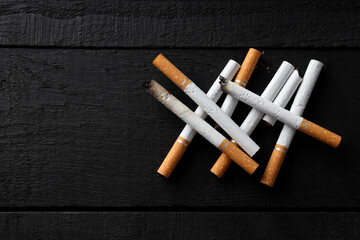 Concept of harm of smoking, cigarettes on dark wooden background