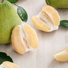 Fresh pomelo fruit on wooden table background.