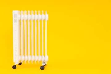 Modern white electric heater on yellow background