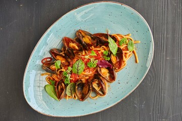 Pasta with mussels with red sauce. Food from the chef in a restaurant or cafe.