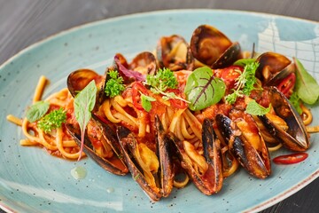 Pasta with mussels with red sauce. Food from the chef in a restaurant or cafe.