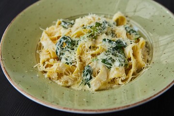 Pasta with parmesan and spinach. Food from the chef in a restaurant or cafe.