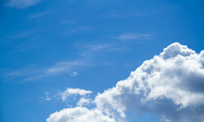 Summer sky. Cumulus clouds on a blue background. Partly cloudy.
