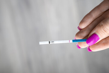 close-up of a woman hand holding a pregnancy test tube result, false negative pregnancy test result, hcg level to detect hormone, problems to get pregnant, family planning