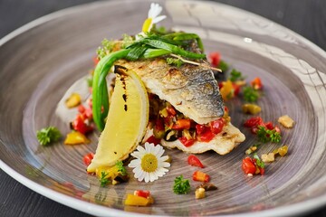 Baked fish with lemon and vegetables. Food from the chef in a restaurant or cafe.