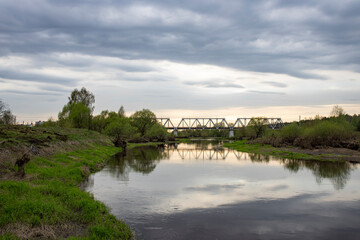 Naklejka na ściany i meble Spring landscape, dramatic sky over the river. View of the river in the evening.