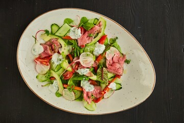 Salad of meat, vegetables and herbs. Food from the chef in a restaurant or cafe.