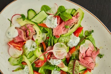 Salad of meat, vegetables and herbs. Food from the chef in a restaurant or cafe.