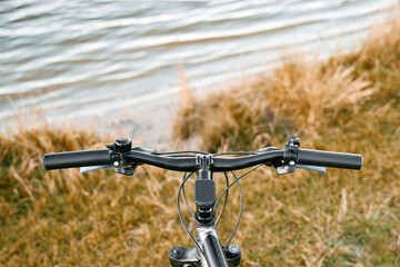 Fototapeta na wymiar POV bike handlebar with a nature backdrop. Leisure time in summer evening concept.