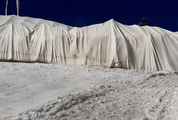 giant cracks in the glacier even 10 meters deep. melting ice causes problems in mountain ski resorts. the ice is covered with a white fabric so that the lifts can work - obrazy, fototapety, plakaty