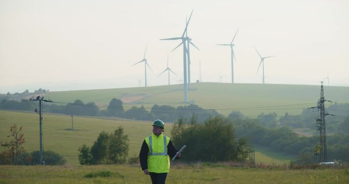 A technician with plans walks through a wind farm in Krystofovy Hamry. Czech republic