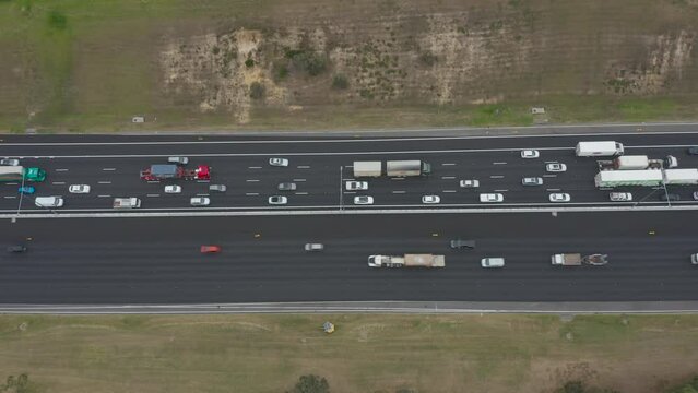 Static aerial perspective looking directly down over busy highway with traffic moving slowly on one side and nominal on the other.