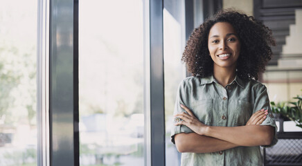Smiling young businesswoman portrait, Self confident young woman with crossed arms at office...