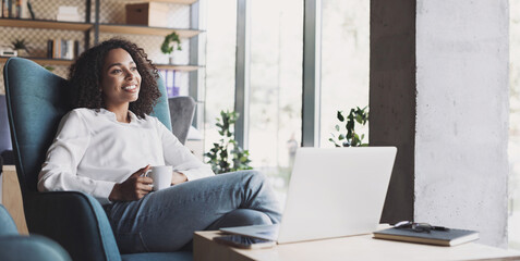 Smiling businesswoman working on laptop computer in office lobby panoramic banner, Young woman professional relaxing at office holding coffee cup, Business people lifestyle concept