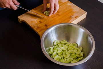 man hands cutting fresh cucumber close up