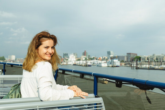 Smiling woman sitting in ferry boat on sunny day