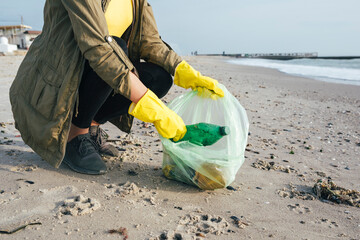 Volunteer picking up waste at beach