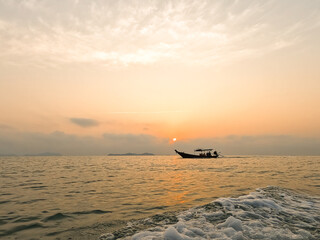 fisherman set sail small fishing boat in the morning sunrise orange light