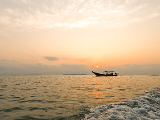 fisherman set sail small fishing boat in the morning sunrise orange light