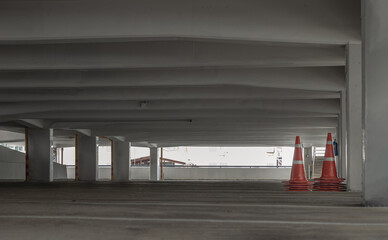 Bangkok, Thailand - 10 Sep 2022 : Orange traffic cones in parking lot building. Perspective view of carpark area with traffic cones in the afternoon, Space for text, Selective focus.