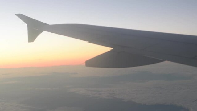 vista desde la ventanilla de un avion de aerolinea del horizonte en el ocaso con el ala del avion desenfocada