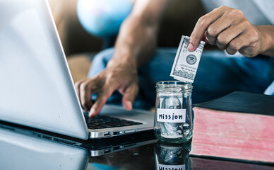 Hands put money in savings jars for mission, christian concept.