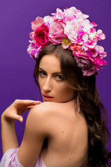 Fototapeta premium Portrait of a Young Woman with Wreath of Pink Flowers on purple Background. Natural Beauty Concept. Ukrainian girl. Save Ukraine
