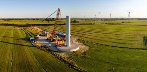 Drone view of the construction site of a modern wind turbine in the start-up phase. In the...